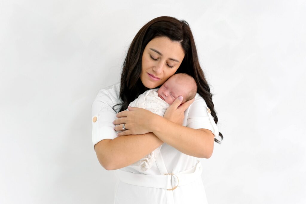 photo de nouveau-né dans les bras de maman